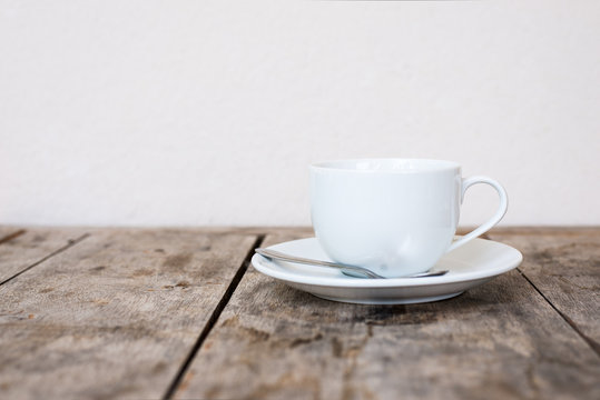 White cup on wood table.