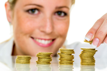 Frau mit Münzstapel beim Geld sparen