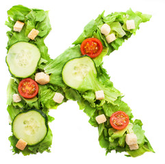K letter made with salad isolated on white