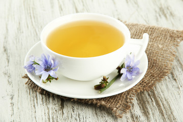 Cup of tea with chicory, on wooden background