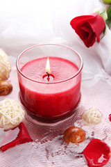Beautiful red candle with flower petals in water