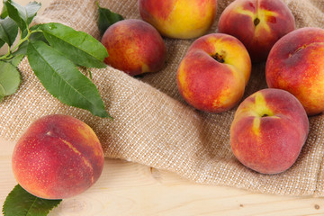 Peaches on sackcloth on wooden table