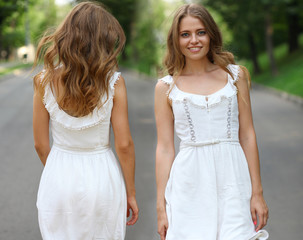 Beautiful young woman walking on the summer park