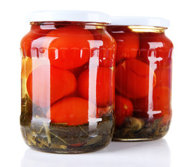 Tasty canned tomatoes in glass jars, isolated on white
