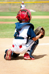 Young baseball catcher during game.