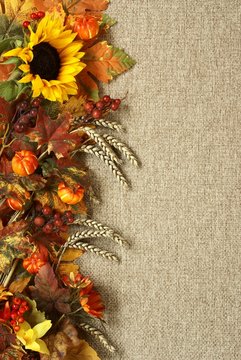 Sunflower, autumn leaves and fruits on burlap background