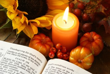 Open Bible, candle, and autumn decorations