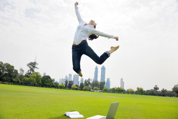 Fototapeta na wymiar young woman jumping in park