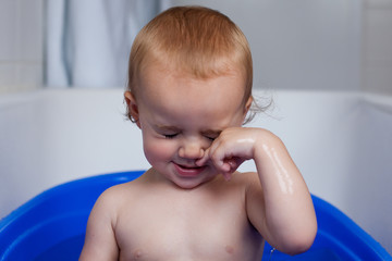 Baby girl crying in bathtub