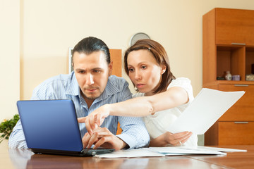 couple staring financial documents  in home