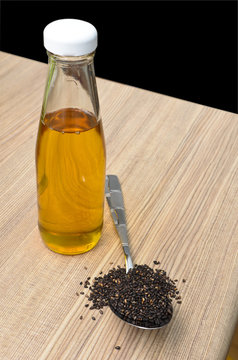 Sesame oil in bottle and black sesame seeds in the spoon