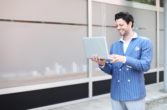 h&uuml;bscher Gesch&auml;ftsmann mit Laptop