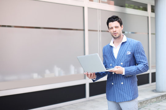 junger Gesch&auml;ftsmann mit Laptop