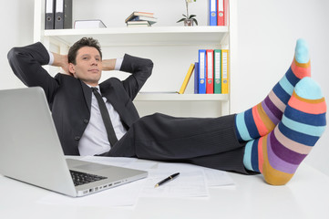 Businessman in funky socks. Confident businessman holding his le