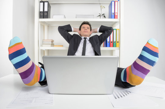 Funky Socks. Happy Businessman In Funky Socks Sitting At His Wor