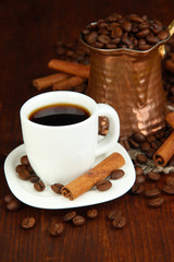 Coffe cup and metal turk on wooden table