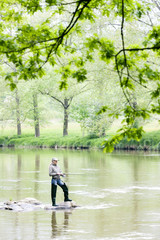 Fototapeta na wymiar woman fishing in Sazava river, Czech Republic