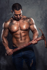 Fototapeta na wymiar Muscular man holding pickaxe