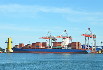 Fototapeta premium Container stack and ship under crane bridge