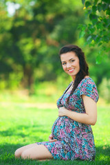 Young beautiful pregnant woman in the park