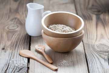 Wooden bowls and a small jug on the wooden background