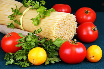 raw spaghetti tie a ribbon, tomatoes and parsley.