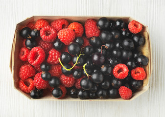 fresh raspberries and black currant berries in a box