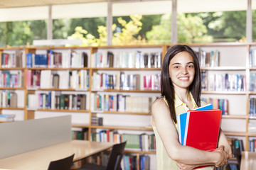 Portrait of pretty girl looking at camera in college library