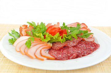Dish with pastrami and salami slices decorated .