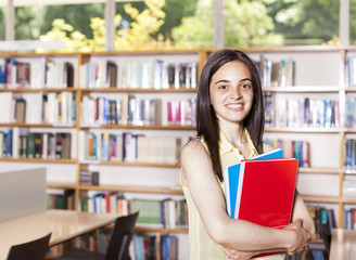 Portrait of pretty girl looking at camera in college library