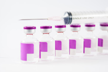 Disable syringe on top arrange purple label vial on white backgr