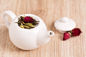 Green tea with fruits, spices, rose petals in a teapot