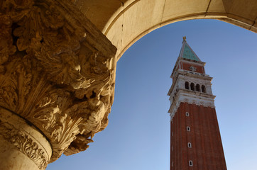 Fototapeta na wymiar An ancient arch and the Clock tower on Piazza San Marco, Venice