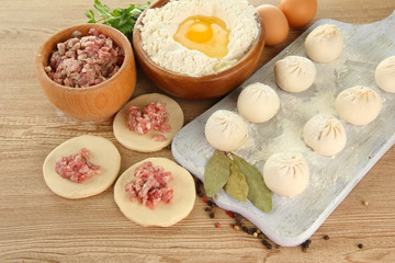 Raw dumplings, ingredients and dough, on wooden table