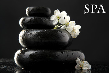 Spa stones and white flowers isolated on black