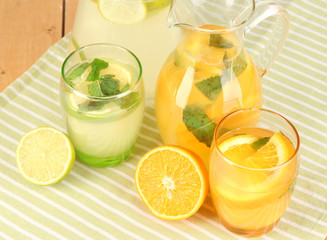 Orange and lemon lemonade in pitchers and glasses