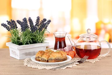 Photo sur Plexiglas Bonbons Sweet baklava on plate with tea on table in room