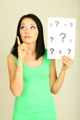 Woman with question marks on grey background