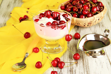 Delicious cherry dessert in glass vase on wooden table close-up