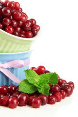 Ripe red cranberries in bowls, isolated on white.