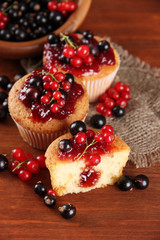 Tasty muffins with berries on wooden table