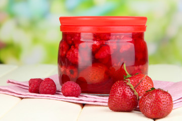 Home made berry jam on wooden table on bright background