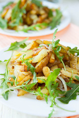 Slices of roasted potatoes and arugula