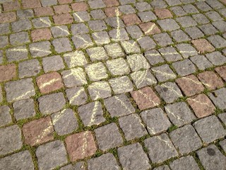 Sonne aus Kreide auf Pflastersteinen