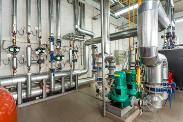 interior gas boiler room with multiple pumps and piping