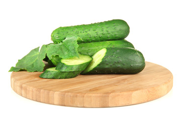 Tasty green cucumbers on wooden cutting board, isolated on