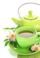 Cup and teapot of herbal tea with hip rose flowers, isolated