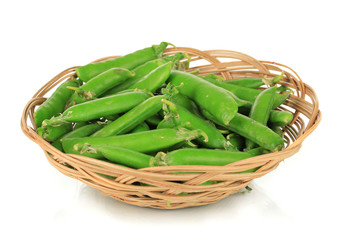 Sweet green peas in wicker basket isolated on white
