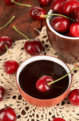 Ripe red cherry berries in cup and chocolate sauce