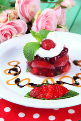 Tasty jelly dessert with fresh berries, on pink roses